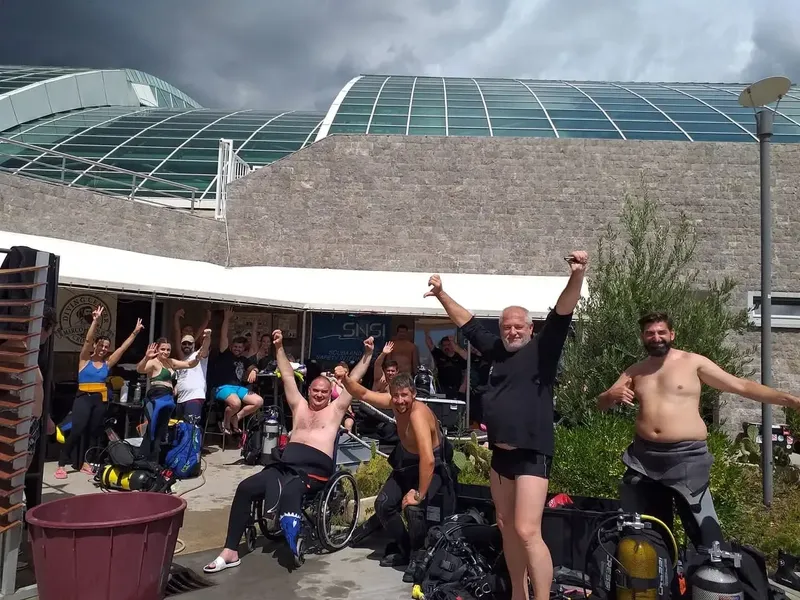 Groupe de plongeurs souriants et célébrant après une sortie en mer