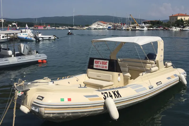 Bateau semi-rigide beige amarré dans un port ensoleillé avec texte publicitaire