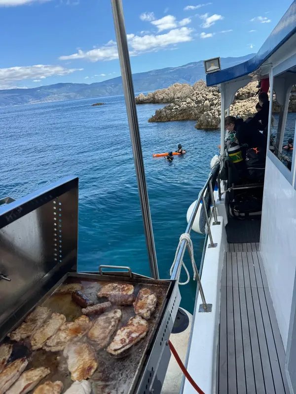 Plongeurs se préparent à bord d'un bateau avec barbecue en cours