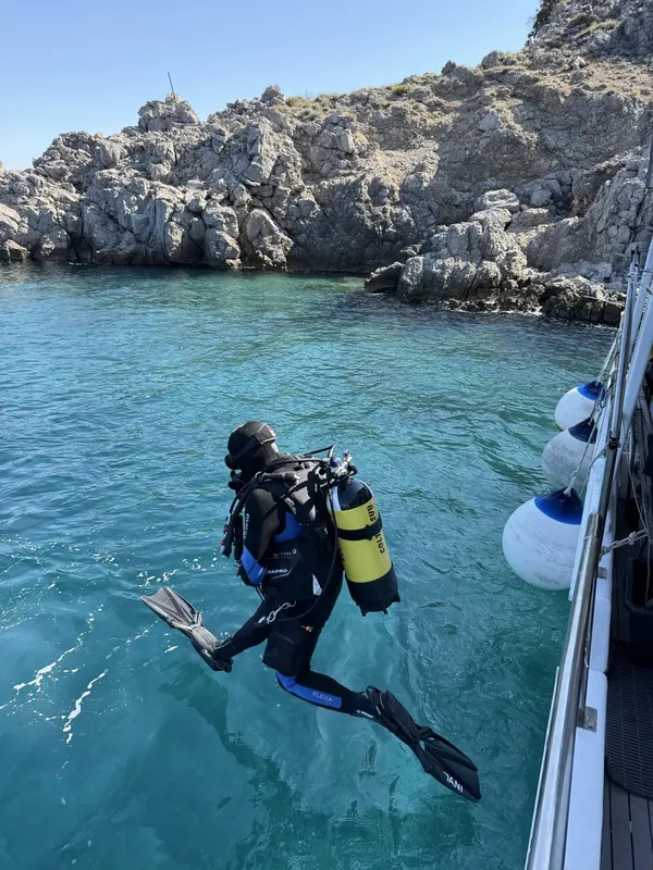 Plongeur s'apprête à entrer dans l'eau depuis un bateau en mer