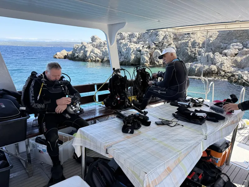 Deux plongeurs s'équipent sur le pont d'un bateau en mer
