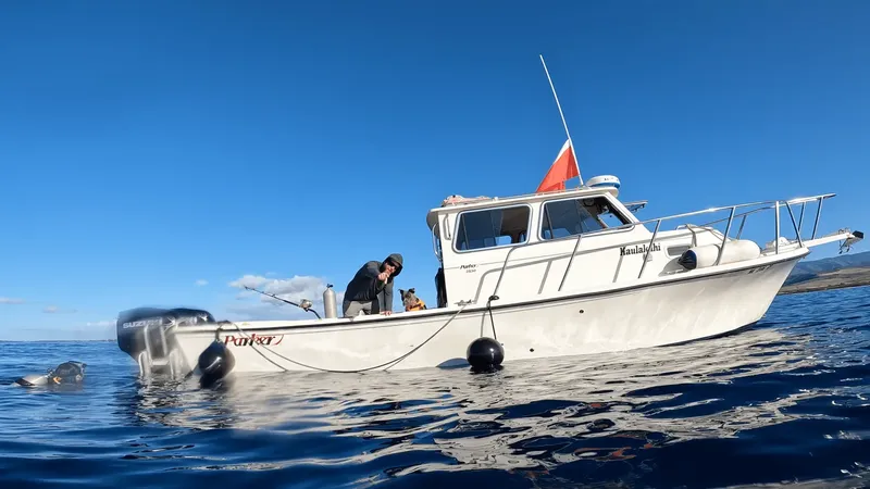 Bateau de plongée blanc avec deux personnes à bord en mer calme
