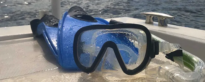 Masque de plongée bleu et tuba sur le pont d'un bateau