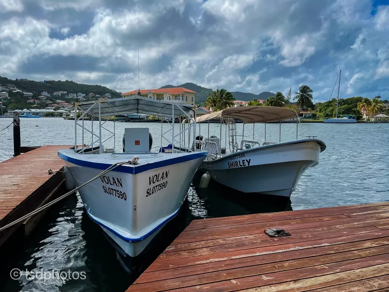 Deux bateaux blancs amarrés à un ponton en bois sous un ciel nuageux