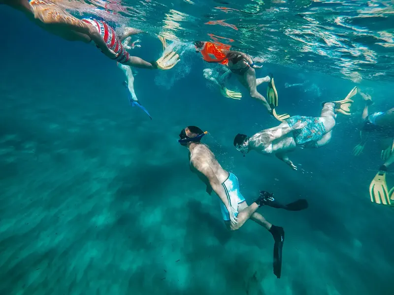 Groupe de nageurs en apnée explorant les fonds marins turquoise