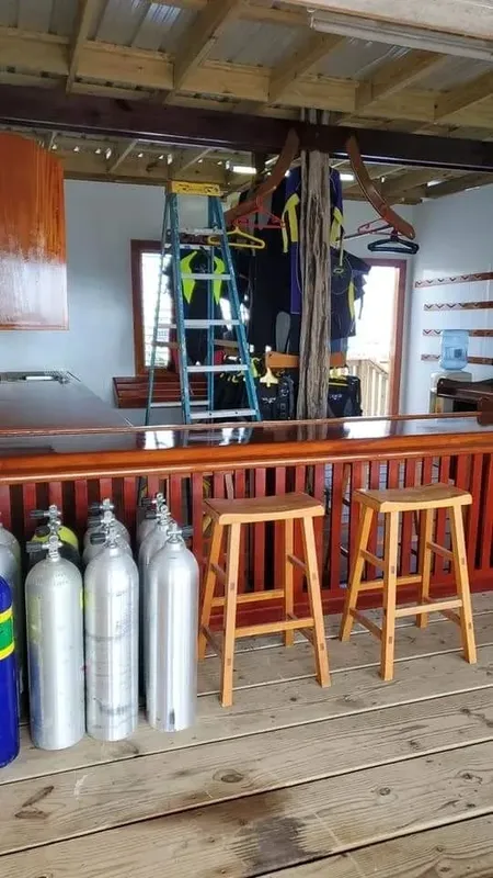Intérieur d'un centre de plongée avec combinaisons, bouteilles et comptoir