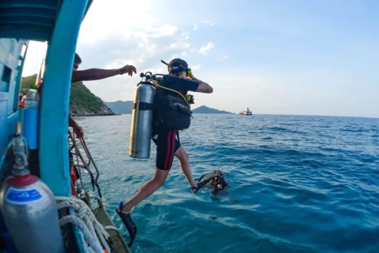 Plongeur s'apprête à sauter d'un bateau en mer, équipement complet