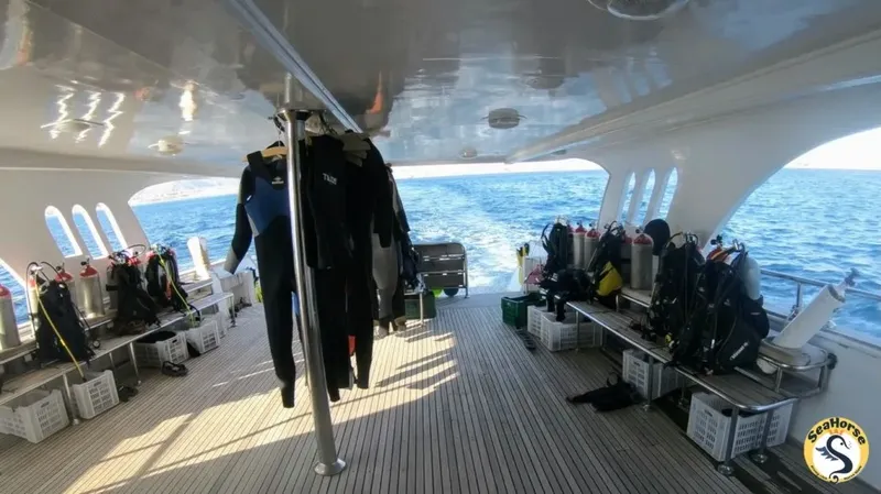 Intérieur d'un bateau de plongée avec combinaisons et équipements prêts à l'emploi