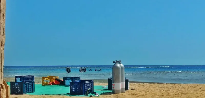 Plage avec des plongeurs et des bouteilles sur le sable