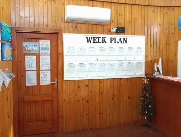 Interieur d'un centre de plongee avec un planning des sorties et un sapin
