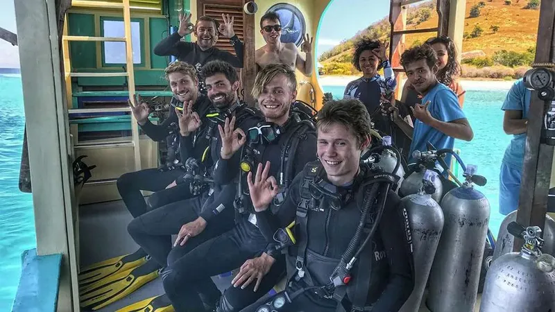 Groupe de plongeurs souriants à bord d'un bateau en direction d'un site