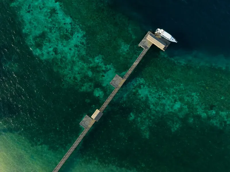 Vue aérienne d'un ponton en bois menant à un bateau amarré