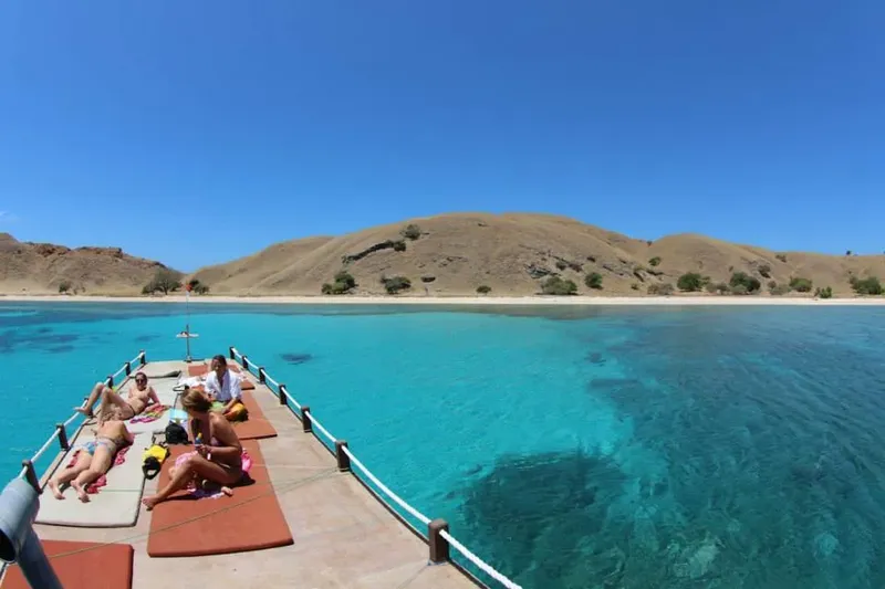Personnes se relaxent sur le pont d'un bateau en mer turquoise