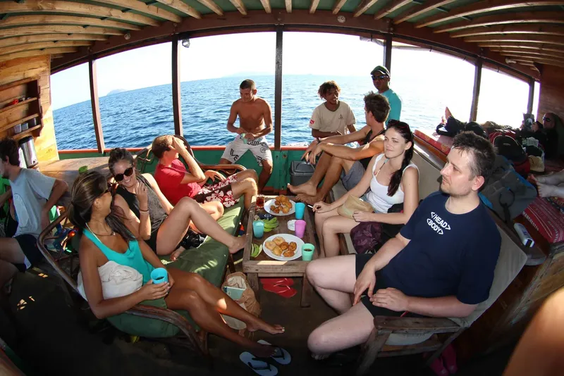 Groupe de personnes à l'intérieur d'un bateau, repas convivial en mer