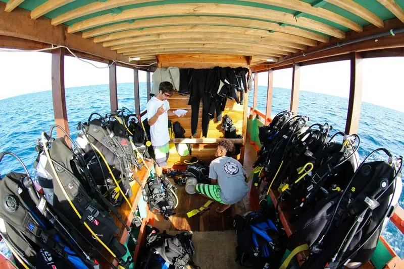 Intérieur d'un bateau de plongée rempli de matériel et de plongeurs