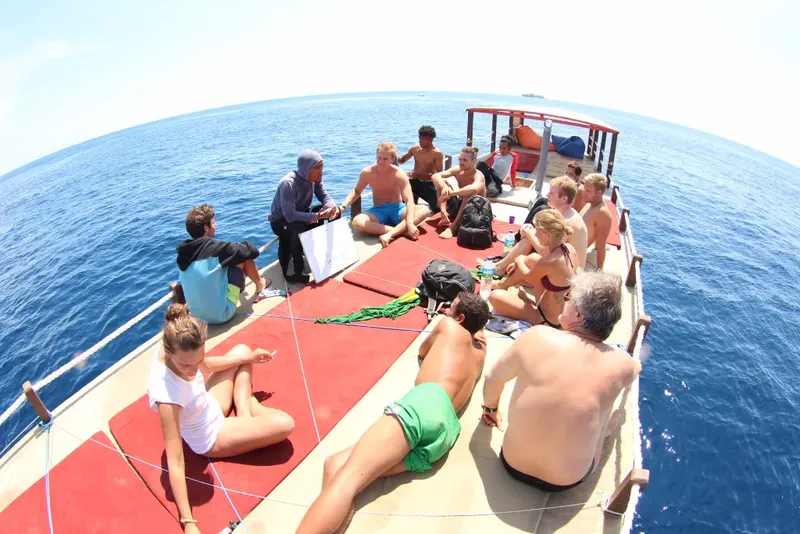 Groupe de personnes assises sur le pont d'un bateau de plongée