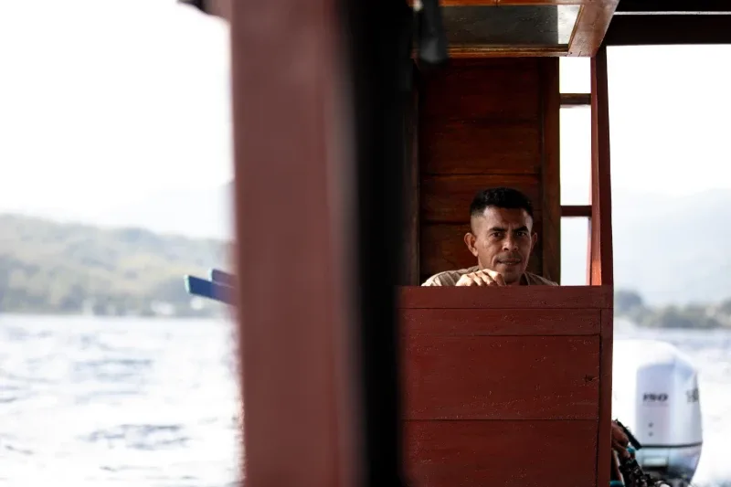 Homme regardant depuis le poste de pilotage d'un bateau en mer