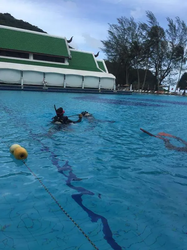 Deux plongeurs s'entraînent dans une piscine avec du matériel