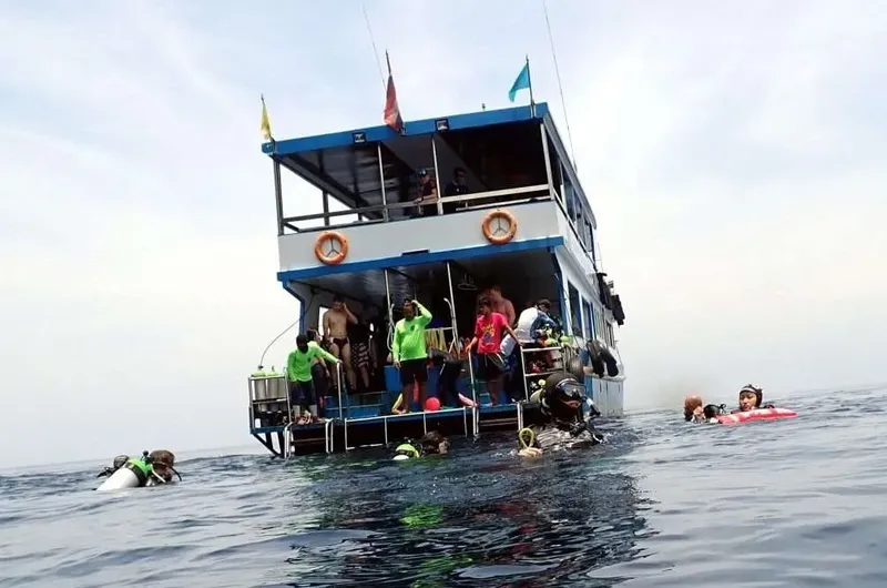 Plongeurs et nageurs autour d'un bateau de plongée en mer