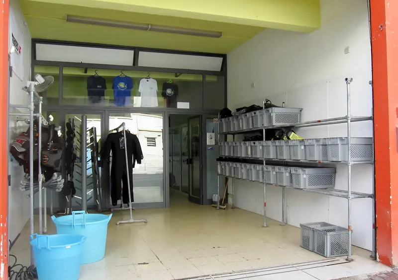 Entrée d'un centre de plongée avec équipement et combinaisons visibles