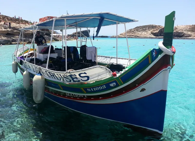 Bateau de plongée coloré amarré dans une crique turquoise ensoleillée