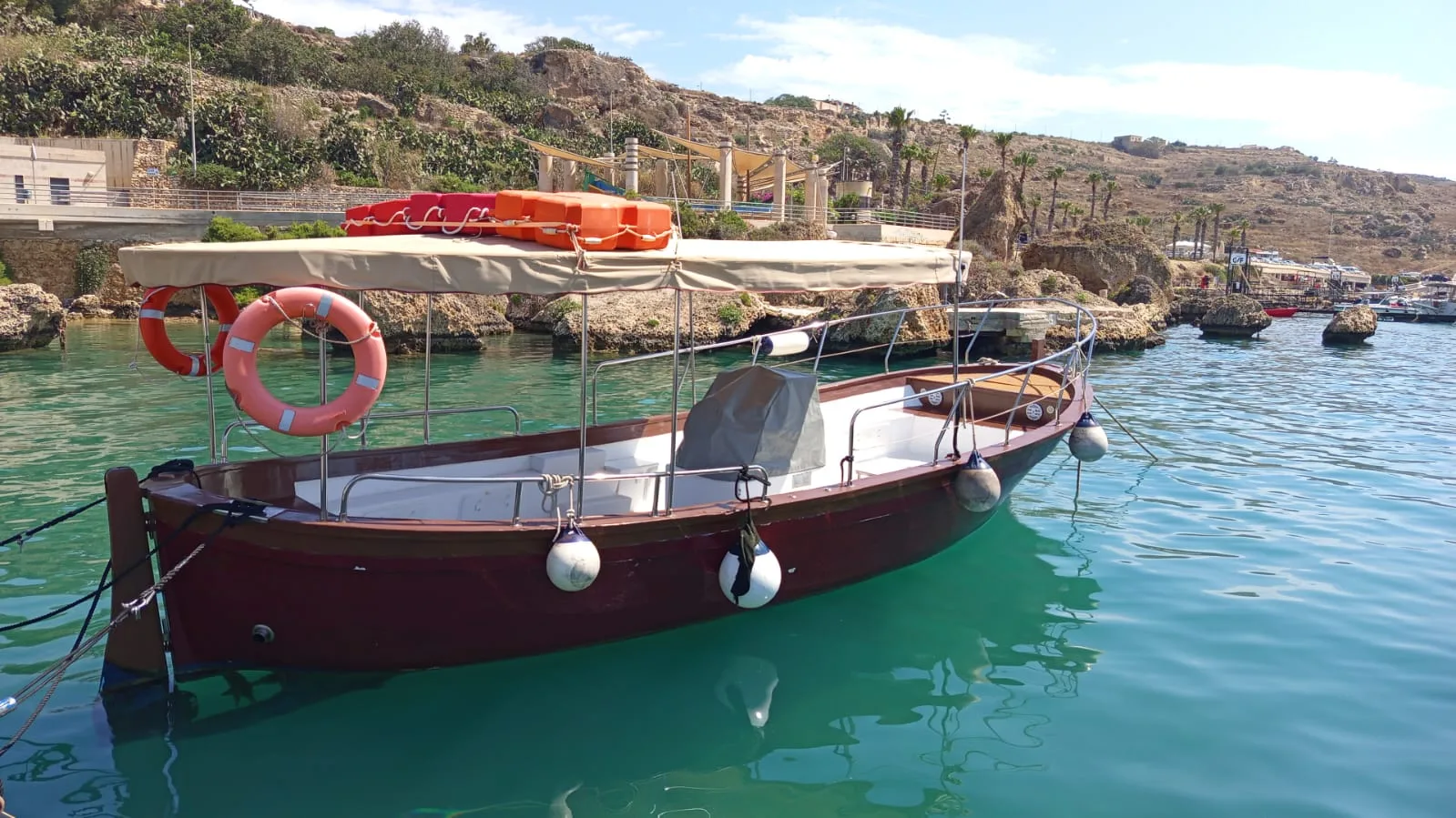 Bateau de plongée amarré dans une crique turquoise ensoleillée