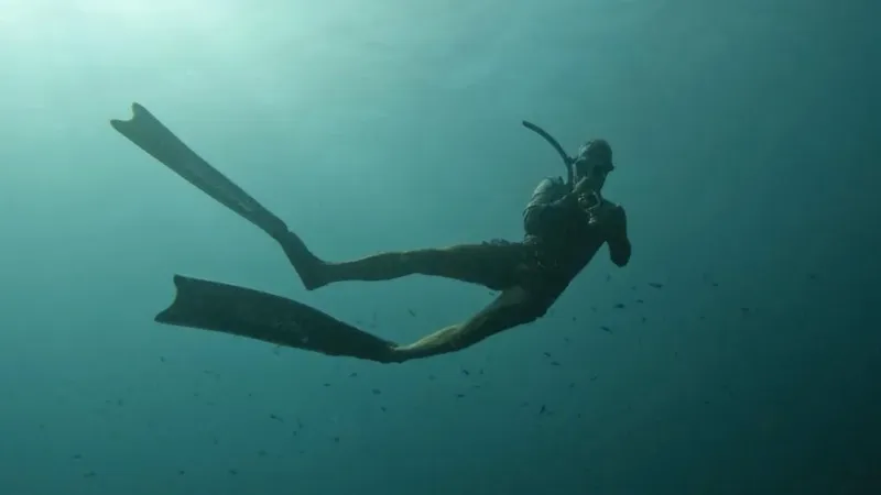 Apnéiste en mouvement dans l'eau bleue, nageant avec des palmes