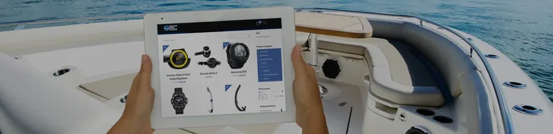 Main tenant une tablette affichant des montres de plongée sur un bateau