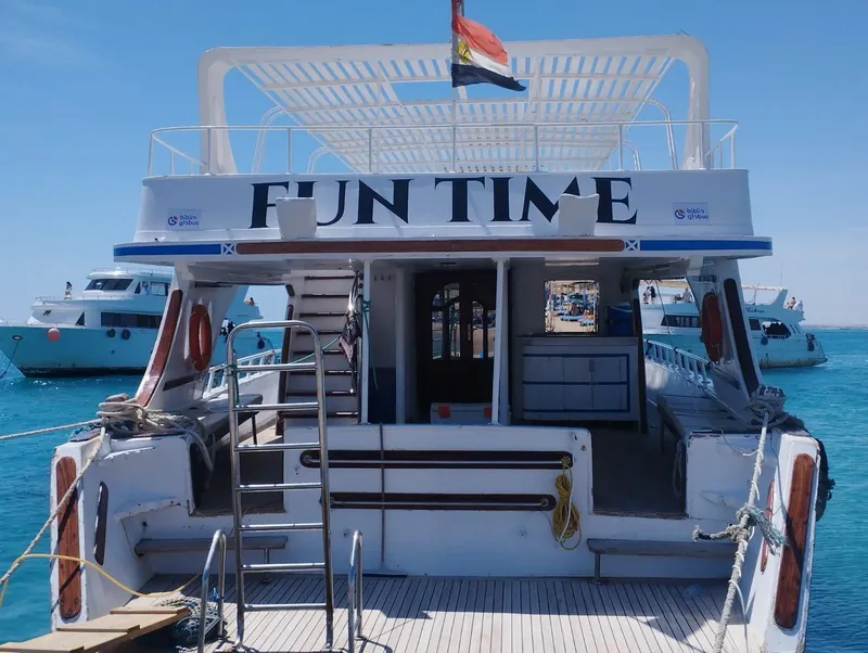 Vue arrière d'un bateau de plongée blanc avec le texte FUN TIME