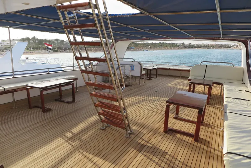 Terrasse en bois d'un bateau de plongée avec assises et tables