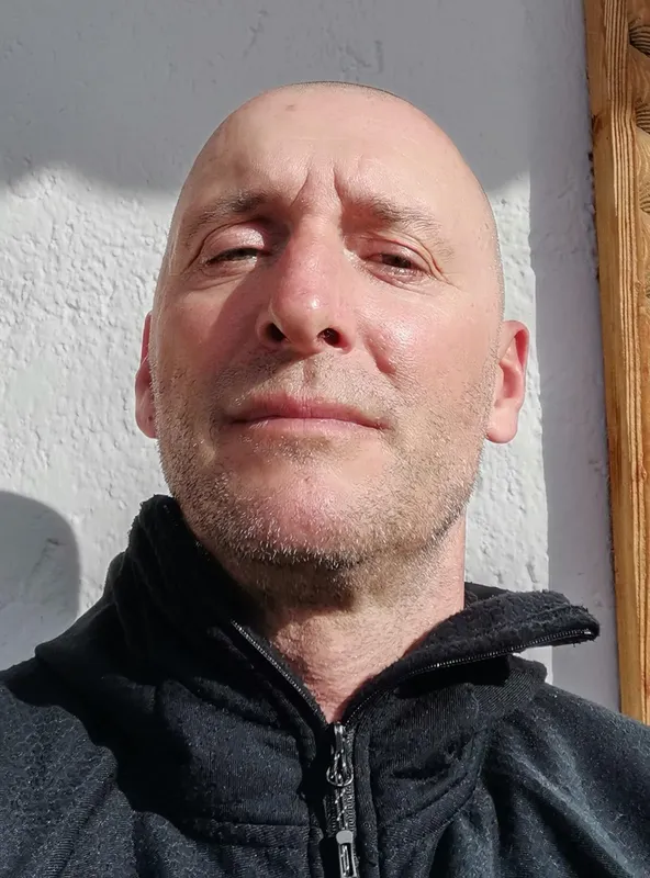 Portrait d'un homme chauve avec une barbe courte regardant légèrement vers le haut