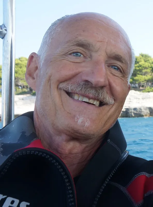 Homme souriant portant une combinaison de plongée sur un bateau