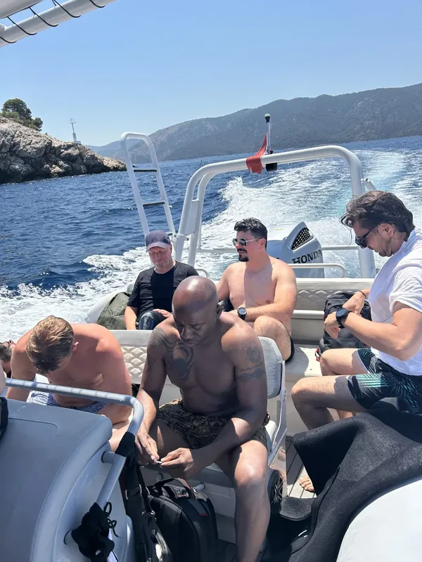 Groupe de plongeurs à bord d'un bateau semi-rigide en mer