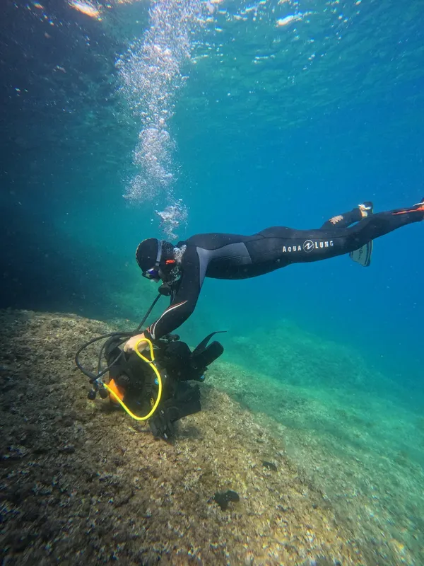 Plongeur en combinaison explore les fonds marins avec son équipement