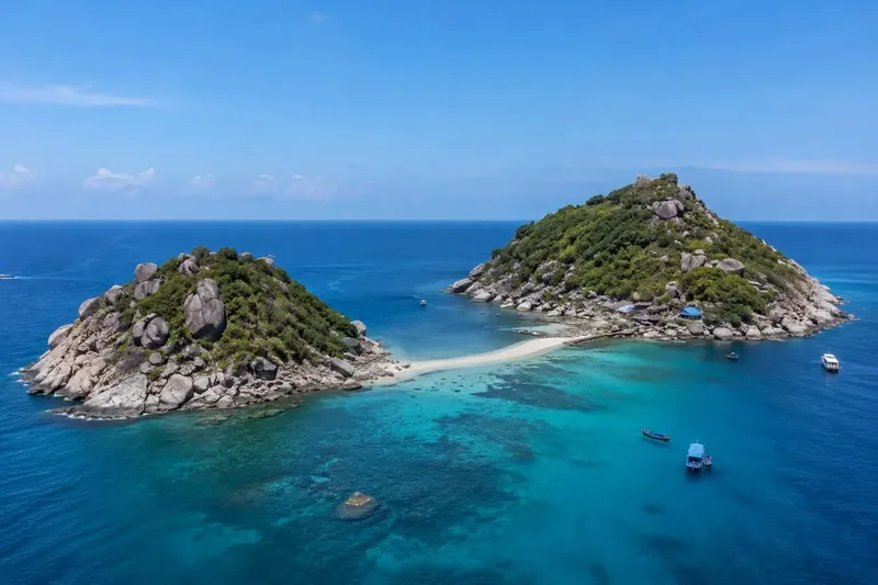Deux îlots rocheux reliés par une bande de sable blanc turquoise