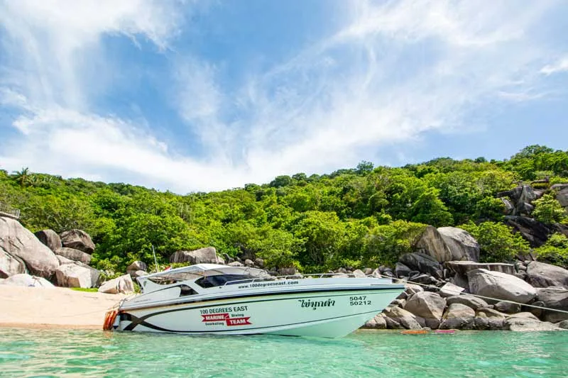 Speedboat blanc échoué sur une plage de sable fin tropicale