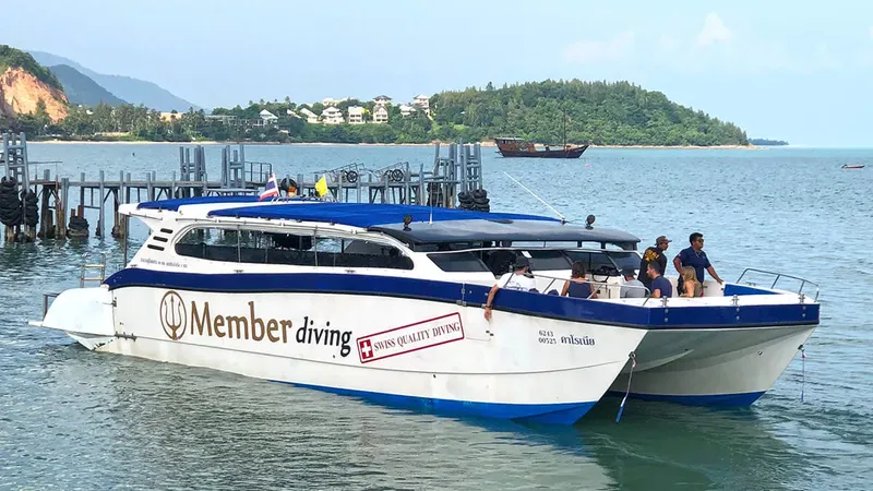 Catamaran de plongée amarré à un ponton avec des passagers à bord