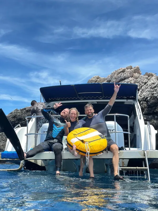 Groupe de plongeurs souriants sur un bateau en mer, joie et excitation