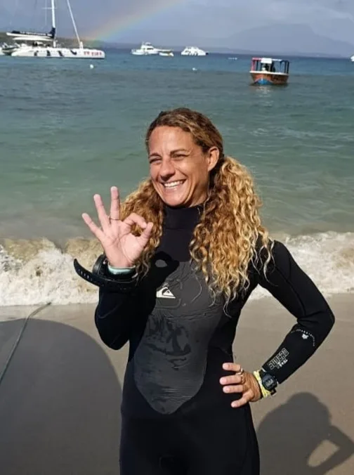 Plongeuse souriante fait le signe OK sur une plage ensoleillée