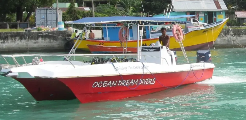 Bateau de plongée rouge et blanc amarré avec du matériel et des personnes