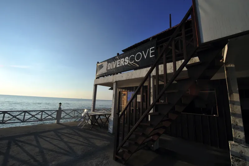 Façade d'un centre de plongée avec escalier et vue sur la mer