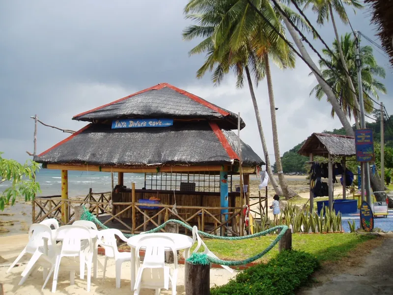 Petite structure de plage avec tables, chaises et un centre de plongée
