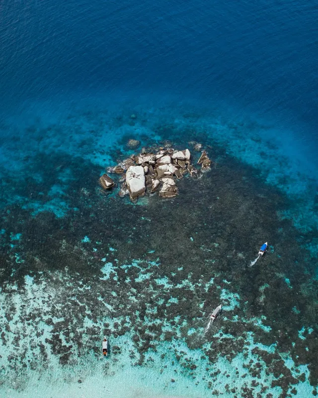 Vue aérienne de plongeurs explorant un récif corallien turquoise