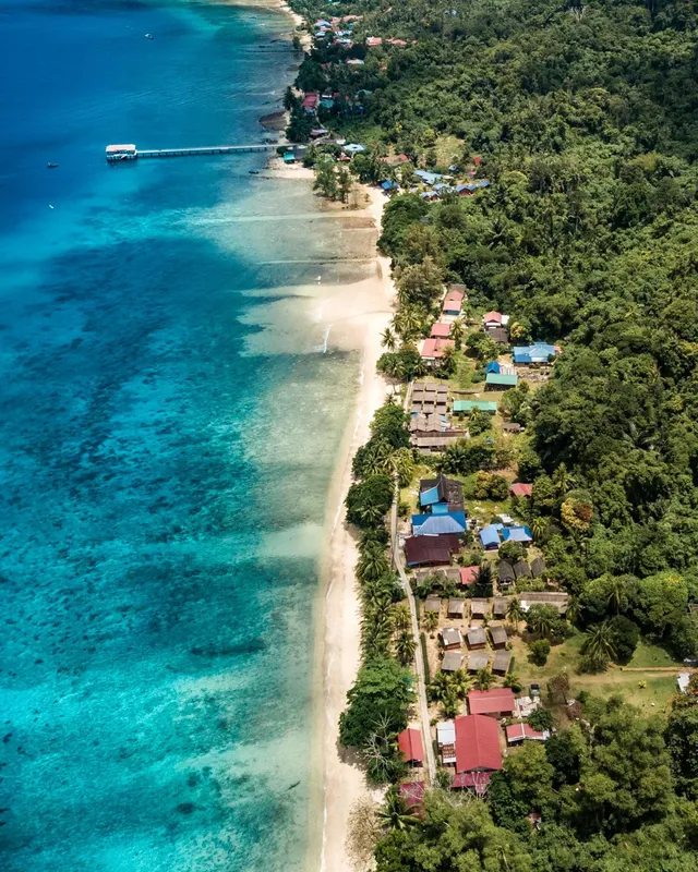 Vue aérienne d'une plage tropicale avec des bâtiments et un ponton