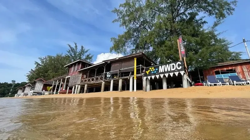 Bâtiments en bois sur pilotis au bord de l'eau avec du matériel
