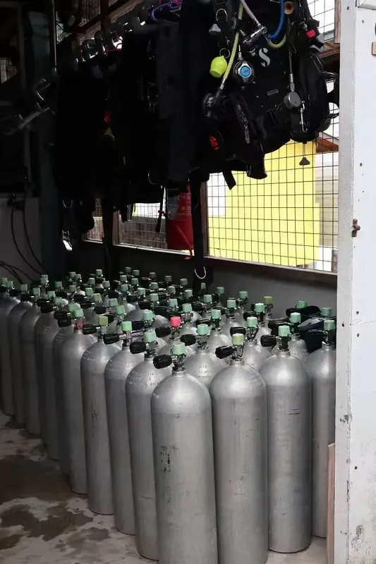 Rangées de bouteilles de plongée et équipements suspendus dans un local