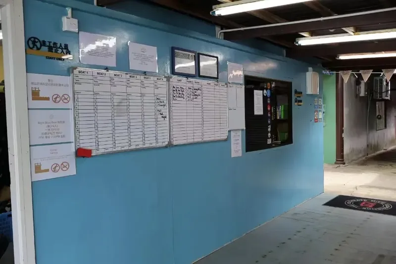 Tableaux de planification et informations affichées sur un mur bleu clair