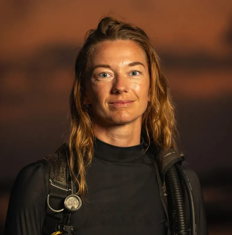 Portrait d'une personne souriante avec équipement de plongée sur les épaules
