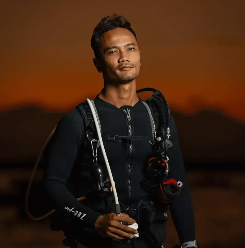 Plongeur équipé regardant la caméra avec un léger sourire