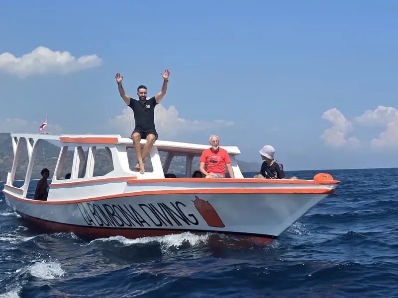Bateau de plongée en mer avec des personnes souriantes et joyeuses